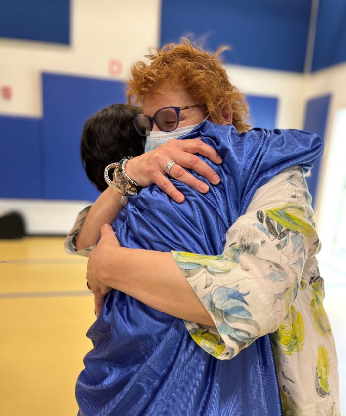 A Wellspring staff member hugs a graduate of Arch Bridge School