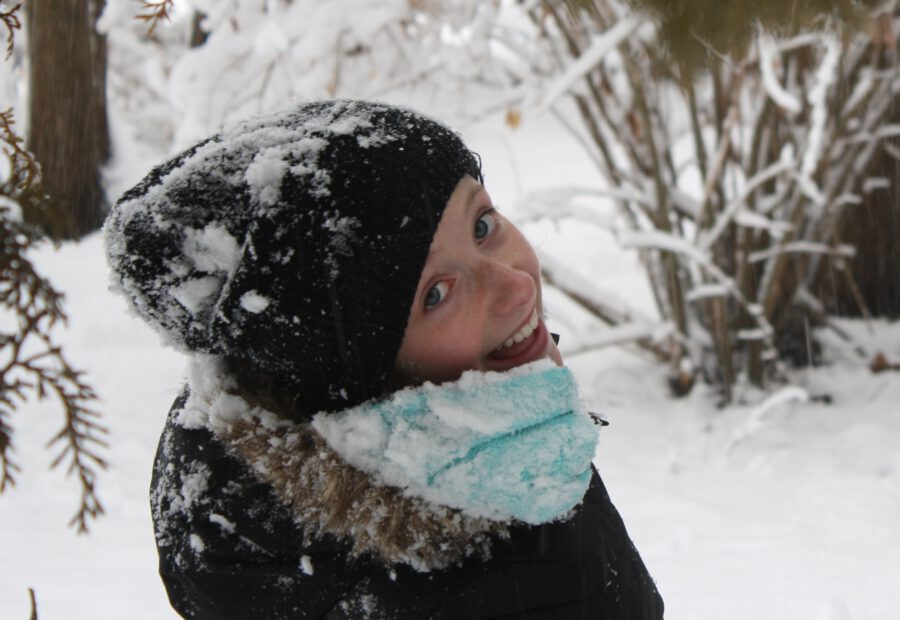 Girl smiling while playing in the snow