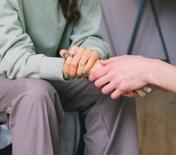 Two people holding hands in a counseling session